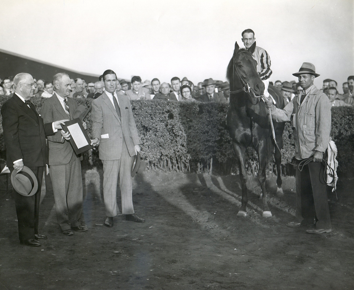 Tom Fool (Ted Atkinson up), Ashley T. Cole, trainer John M. Gaver, Sr., and James Butler  in the winner's circle at Empire City  for his "farewell to the turf" in November 1953 (Empire City Photo/Museum Collection)